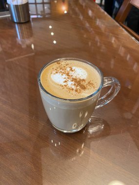 Tarçınlı cam bardakta balkabağı aromalı latte, yerel kafe dükkanında hindistan cevizi. İçmeye hazır..