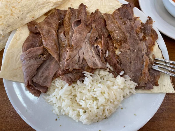 Turkish Doner Kebab on plate. Arabic traditional doner with pita bread lavash. Protein nutrition, clean eating, diet concept. Turkish, greek or middle eastern style doner kebab food restaurant. ready