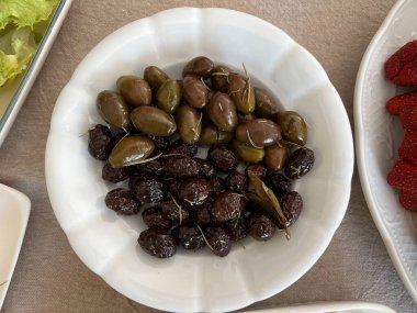 Zeytin ağacı brunch 'lı bir tabakta taze zeytin çeşitleri. Yemek hazır..
