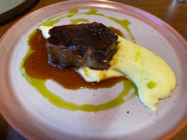 Restoranda ızgara domuz pirzolası, patates püresi, ızgara sos, duman, baharat ve biberiye servis ediliyor. Yemek için hazır..