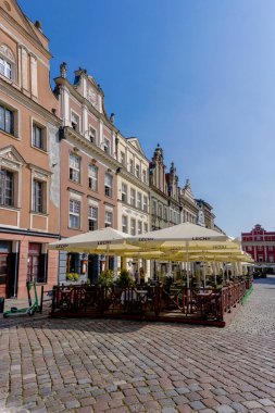 Poznan, Polonya - 8 Eylül 2021: Poznan 'ın eski pazar meydanında açık hava restoranları olan renkli Rönesans mimari binaları