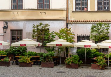 Lublin, Polonya - 13 Eylül 2021: Lublin 'in tarihi şehir merkezinde güneş şemsiyeli birçok bitki ve açık hava restoranı olan eski püskü binalar