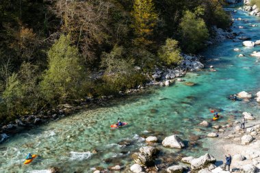 Kobarid, Slovenya - 17 Ekim 2021: Slovenya 'nın kuzeyindeki dağlardaki Soca Nehri' nin berrak turkuaz sularında kürek çeken kayakçılar
