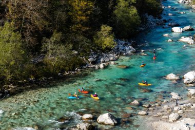 Kobarid, Slovenya - 17 Ekim 2021: Slovenya 'nın kuzeyindeki dağlardaki Soca Nehri' nin berrak turkuaz sularında kürek çeken kayakçılar