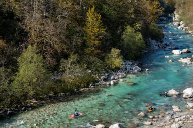 Kobarid, Slovenya - 17 Ekim 2021: Slovenya 'nın kuzeyindeki dağlardaki Soca Nehri' nin berrak turkuaz sularında kürek çeken kayakçılar