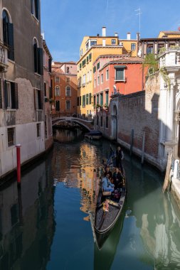 Venedik, İtalya - 15 Ekim 2021: Venedik 'in dar kanallarında seyahat eden turistlerle gondol