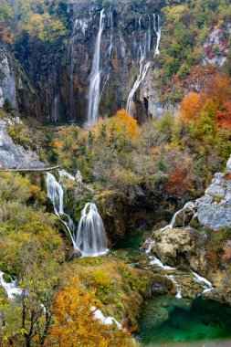Plitivice 'deki büyük şelalelerin dikey görüntüsü canlı ve renkli sonbahar yeşillikleriyle