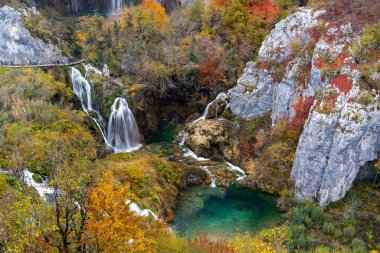 Plitivice 'deki büyük şelalelerin canlı ve renkli sonbahar yeşillikleriyle manzarası