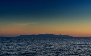 Günbatımında Cres Adası silueti olan Kvarna Körfezi manzarası.