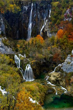 Plitivice 'deki büyük şelalelerin dikey görüntüsü canlı ve renkli sonbahar yeşillikleriyle