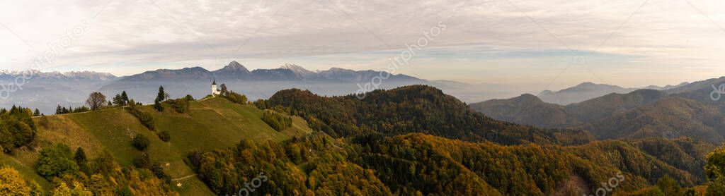 A panorama view of the Church of Saint Primoz and the Julian Alps in late autumn