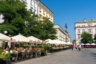 Krakow, Polonya - 15 Eylül 2021: Krakow 'un ana meydanı. Açık hava evleri ve tarihi sanat eserleri yeni binaları var.