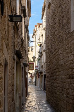 Trogir, Hırvatistan - 10 Kasım 2021: tarihi şehir merkezi Trogir 'deki kaldırım taşı caddesi ve eski binalarla dar bir sokak