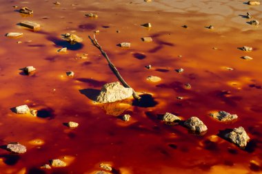 Terk edilmiş eski bir madende zehirli ve zehirli suyu olan renkli küçük bir gölet.