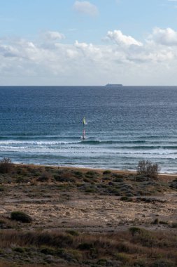 Güney Murcia 'daki Calblanque Bölge Parkı' nın tenha sahillerinde rüzgar sörfü.