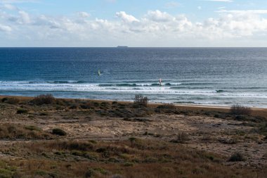 Güney Murcia 'daki Calblanque Bölge Parkı' nın tenha sahillerinde rüzgar sörfü.
