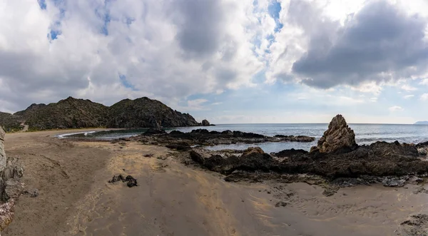 岩の多い山間の海岸線にひっそりと佇む砂浜のパノラマビュー — ストック写真