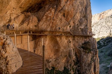 El Chorro, İspanya - 22 Şubat 2022: turistler gösterişli bir kış gününde Camino del Rey 'de yürüyüş yapmayı severler.