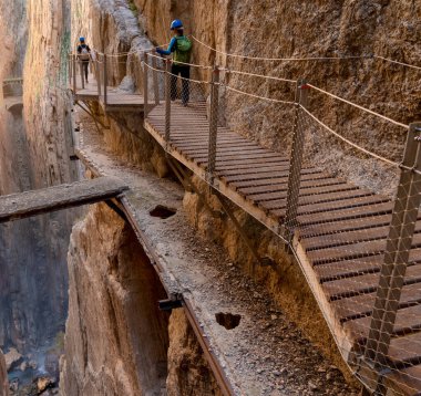 El Chorro, İspanya - 22 Şubat 2022: turistler gösterişli bir kış gününde Camino del Rey 'de yürüyüş yapmayı severler.