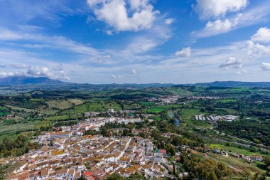 Jimena de la Frontera, İspanya - 9 Mart 2022: Beyaz boyalı Jimena de la Frontera köyü yüksek açılı çatı ve kilise manzaralı