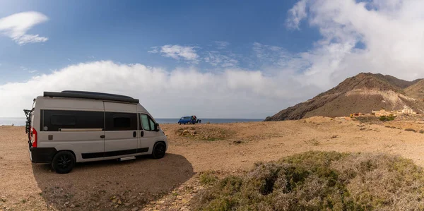 Cabo de Gata, İspanya - 3 Mart 2022: Endülüs 'ün vahşi sahillerindeki kayalık bir plaja kamp araçları park etti.