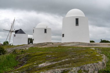 Evora, Portekiz - 24 Mart 2022: Evora 'lı Sao Bento' nun yel değirmenleri bulutlu gökyüzü altında