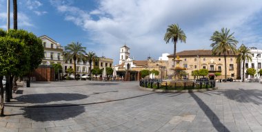 Merida, İspanya -- 28 Mart 2022: Merida şehir merkezindeki Plaza de Espana Meydanı 'nın çeşmesi ve palmiye ağaçları ile panorama manzarası