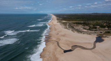 Uçsuz bucaksız, uçsuz bucaksız, altın bir kumsal ve okyanusa akan bir nehir.