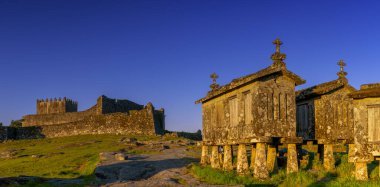 Lindoso Kalesi ve Portekiz 'in Lindoso köyündeki tarihi taş ambarları sıcak akşam ışığında
