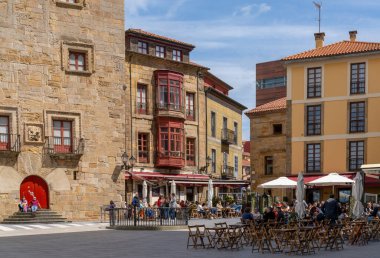 Gijon, İspanya - 24 Nisan 2022: Plazuela de Marquez Meydanı 'nın güneşli bir hafta sonunun keyfini çıkaran birçok insanla dolu ve hareketli manzarası