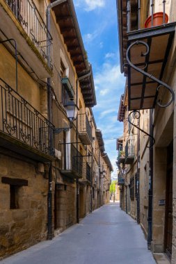 Laguardia, Spain - 26 April, 2022: narrow picturesque street with brown stone buildings in the historic city center of Laguardia in La Rioja