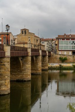 Miranda de Ebro, İspanya - 3 Mayıs 2022: Ebro Nehri üzerindeki taş köprünün dikey görüntüsü ve Miranda de Ebro 'nun tarihi şehir merkezi