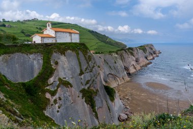 Zumaia 'daki San Telmo Hermitage kilisesi ve Flysch kaya oluşumlarının manzarası.