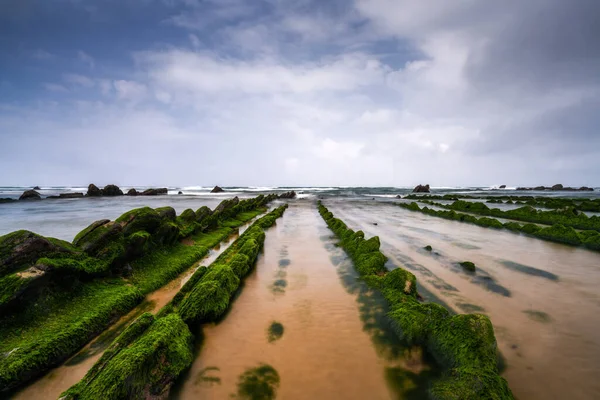 Bilbao yakınlarındaki Barrika sahilinde Flysch kaya oluşumlarının uzun pozlu görüntüsü.