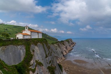 Zumaia 'daki San Telmo Hermitage kilisesi ve Flysch kaya oluşumlarının manzarası.
