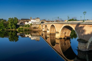 Bergerac, Fransa - 11 Mayıs 2022: Dordogne Nehri manzarası ve Bergerac 'a giden eski taş köprü