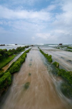 Bilbao yakınlarındaki Barrika sahilinde Flysch kaya oluşumlarının uzun pozlu görüntüsü.