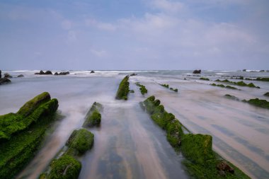 Bilbao yakınlarındaki Barrika sahilinde Flysch kaya oluşumlarının uzun pozlu görüntüsü.