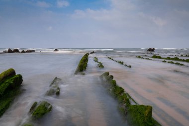 Bilbao yakınlarındaki Barrika sahilinde Flysch kaya oluşumlarının uzun pozlu görüntüsü.