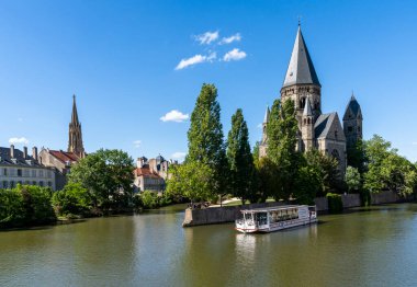 Metz, Fransa - 1 Haziran 2022: Tarihi şehir merkezi Metz 'deki Moselle Nehri ve Yeni Tapınak manzarası ve ön planda bir turistik tekne turu
