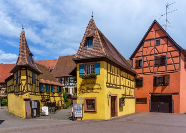 Eguisheim, Fransa - 29 Mayıs 2022: Eguisheim şehir merkezindeki tarihi renkli yarı ağaçlı evler ve şarap mahzenleri