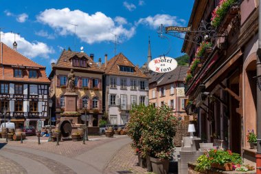 Ribeauville, Fransa - 30 Mayıs 2022: Köy meydanında fıskiye ve şarap fıçılarıyla Ribeauville 'in tarihi köy merkezi