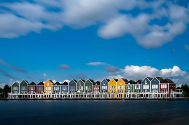 Houten, Hollanda - 9 Haziran 2022: Houten 'deki renkli gökkuşağı evleri ve göl manzarası