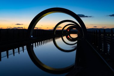 Falkirk, Birleşik Krallık - 19 Haziran 2022: Günbatımında Falkirk Tekerleği 'nin farklı parlak renklerde görüntüsü