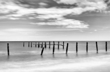 Happisburgh Sahili 'ndeki terk edilmiş eski deniz savunmasının siyah beyaz görüntüsü.