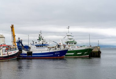 Greencastle, İrlanda - 9 Temmuz 2022: Greencastle limanı ve limanında renkli balıkçı tekneleri ve balıkçılar