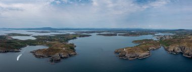 A panorama view of the entrance to the Baltimore Harbor in West Cork with teh Sherkin Island Lighthouse and the Baltimore Beacon
