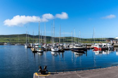 Dingle, Ireland - 7 August, 2022: view of many sailboats in the marina and harbor in Dingle village in County Kerry