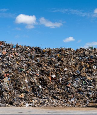 A large pile of scrap metal and waste at a recycling plant