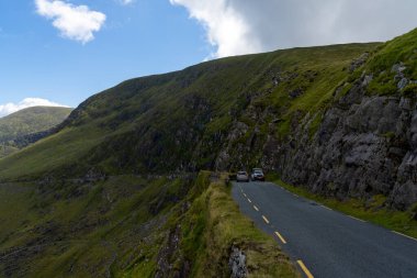 Dingle, Ireland - 7 August, 2022: cars try to pass each other on the very narrow road leading to Connor Pass on the Dingle Peninsula in County Kerry